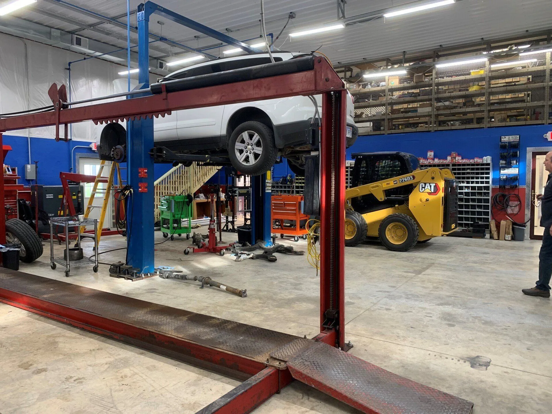 A car is sitting on a lift in a garage.